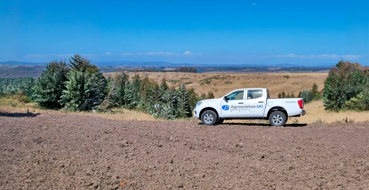 Imagen de la camioneta del laboratorio Agroanálisis estacionada en un campo, lista para la toma de muestras de suelo. La camioneta se encuentra en primer plano, destacando su presencia en el entorno rural, mientras que alrededor se observa el campo abierto. Esta imagen sugiere la movilización del equipo de análisis de suelo y su compromiso con la investigación agrícola, resaltando la importancia de la toma de muestras para la evaluación y mejora de la calidad del suelo